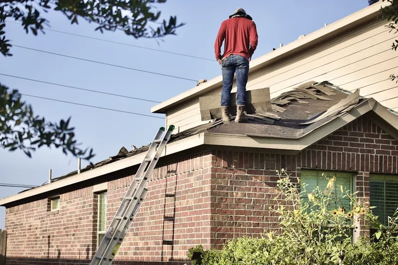 Professional roofer working on a residential roof in Rivermont